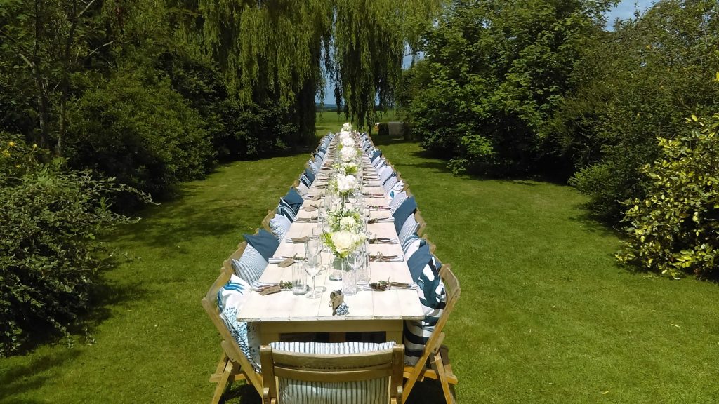 A Summer lunch setting with wooden trestle tables