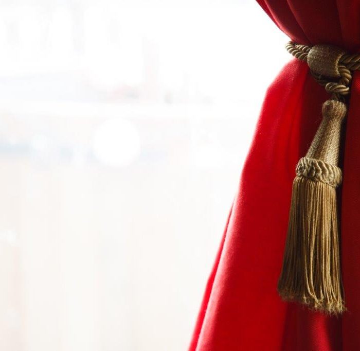 A gold tie back holds a Scarlet lining in place